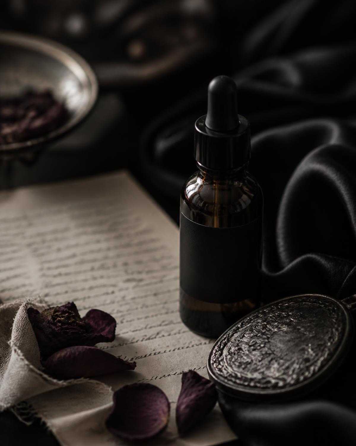 A handwritten family recipe card beside dried herbs and a small amber bottle